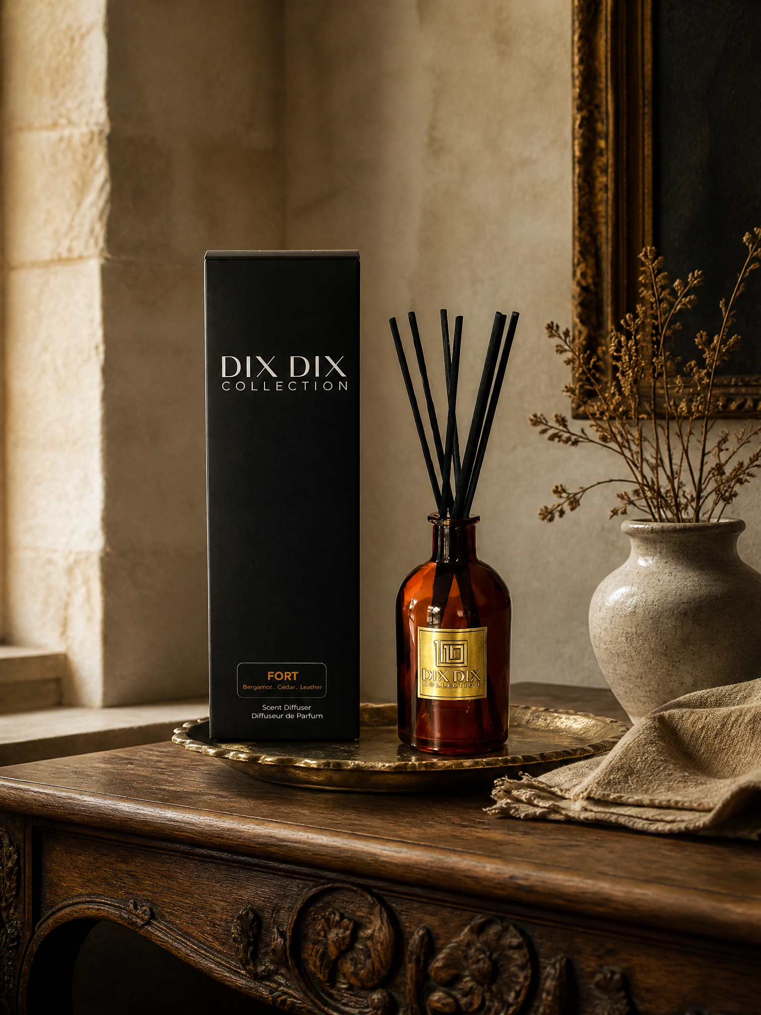 Velorae Essence FORT scent reed diffuser in amber glass beside the DIX DIX Collection box on a wooden table